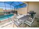 Enclosed patio with pool and metal table and chairs at 1507 Carey Palm Cir, Kissimmee, FL 34747