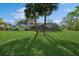 Lush green backyard featuring a screened-in pool enclosure, mature trees, and plenty of space for outdoor activities at 1606 Wildcat Ct, Winter Springs, FL 32708