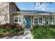Close-up of the home's front entrance with a charming blue door, stone accents, and well-maintained landscaping at 1606 Wildcat Ct, Winter Springs, FL 32708