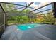 A beautiful screened-in swimming pool surrounded by a concrete deck and lush greenery offers a private outdoor oasis at 1606 Wildcat Ct, Winter Springs, FL 32708