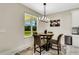 Cozy dining area with a round table, upholstered chairs, modern light fixture, and view of the backyard at 1610 6Th Ave, Deland, FL 32724