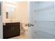 Bathroom with dark cabinets, a granite countertop, tile floors, and shelving unit at 16893 Sw 17Th Ter, Ocala, FL 34473
