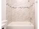 Bathroom showcasing a bathtub with marble-look tile surround and neutral paint at 16893 Sw 17Th Ter, Ocala, FL 34473