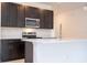 Stylish kitchen featuring modern appliances, dark cabinetry, and a white island with a breakfast bar at 16893 Sw 17Th Ter, Ocala, FL 34473