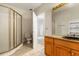 Bathroom with a glass-enclosed shower, toilet, tiled floor and vanity with decorative mirror at 19715 Eaglesview Cir, Umatilla, FL 32784