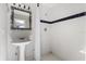Bright bathroom featuring a pedestal sink, shower with white tiling and blue stripe at 19715 Eaglesview Cir, Umatilla, FL 32784