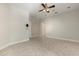 Neutral bedroom with tile flooring, ceiling fan, and open door to the hallway, providing a bright space at 19715 Eaglesview Cir, Umatilla, FL 32784