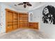 Cozy bedroom featuring custom-built wooden shelving and a decorative ceiling fan at 19715 Eaglesview Cir, Umatilla, FL 32784