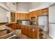 Kitchen featuring wooden cabinetry, an island with cooktop, tile countertops, and backsplash at 19715 Eaglesview Cir, Umatilla, FL 32784
