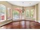 Bright living room showcasing hardwood floors, large arched windows, and chandelier with ample natural light at 19715 Eaglesview Cir, Umatilla, FL 32784