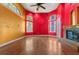 Bright living room with hardwood floors, a ceiling fan, and a cozy brick fireplace at 19715 Eaglesview Cir, Umatilla, FL 32784