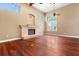 Living room featuring a stone fireplace, ceiling fans, hardwood floors, and large windows with lots of natural light at 19715 Eaglesview Cir, Umatilla, FL 32784