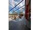 From under the screen enclosure, a view of the unique geometric pool with a glimpse of the lake in the distance at 19715 Eaglesview Cir, Umatilla, FL 32784