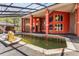 Inviting red-accented pool house featuring a large swimming pool and ample space for relaxation at 19715 Eaglesview Cir, Umatilla, FL 32784