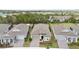 Aerial view of a well-maintained home with a manicured front yard, set in a community near a lush treeline and pond at 2116 Limestone Trl, Kissimmee, FL 34747