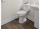Bathroom featuring a wood-look floor, pedestal sink, and toilet at 2116 Limestone Trl, Kissimmee, FL 34747