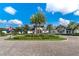 Exterior of a pristine clubhouse with decorative landscaping, palm trees, and brick-paved drive at 2116 Limestone Trl, Kissimmee, FL 34747