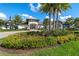Stunning exterior shot of a modern community clubhouse with lush landscaping and swaying palm trees at 2116 Limestone Trl, Kissimmee, FL 34747