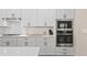 Bright kitchen features white cabinetry, stainless steel appliances, subway tile backsplash, and quartz countertops at 2116 Limestone Trl, Kissimmee, FL 34747