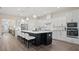 Open-concept kitchen with a large center island, white cabinets, and stainless steel appliances at 2116 Limestone Trl, Kissimmee, FL 34747