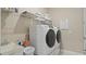 Well-lit laundry room with a sink, modern washer and dryer, and overhead shelving for storage at 2116 Limestone Trl, Kissimmee, FL 34747