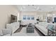Bright living room with wood floors, coastal art, white furnishings, and a glimpse of the modern kitchen at 2116 Limestone Trl, Kissimmee, FL 34747