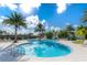 Resort-style community pool with clear blue water, surrounded by palm trees, and lounge chairs at 2116 Limestone Trl, Kissimmee, FL 34747