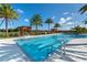 Community pool surrounded by palm trees, lounge chairs, and covered seating under a bright blue sky at 2116 Limestone Trl, Kissimmee, FL 34747