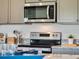Contemporary kitchen with stainless steel microwave and range, shaker cabinets, and granite countertops at 2223 Lake Preserve Cir, New Smyrna Beach, FL 32168
