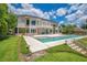 Large home with backyard featuring a pool, lawn, and stairs leading down to the lake at 2504 Gatlin Ave, Orlando, FL 32806