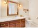 Bathroom features a wood vanity with framed mirror, sconce lighting, and white toilet at 2504 Gatlin Ave, Orlando, FL 32806