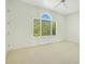 Bright bedroom with neutral carpet, a large window, and light colored walls at 2504 Gatlin Ave, Orlando, FL 32806