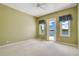 Light green bedroom featuring a ceiling fan, ensuite balcony access, and neutral carpet at 2504 Gatlin Ave, Orlando, FL 32806