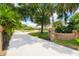 Gated brick entrance to a private drive surrounded by lush landscaping at 2504 Gatlin Ave, Orlando, FL 32806