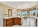 Bright kitchen with white tile floors and wood cabinetry, with scenic view from breakfast nook at 2504 Gatlin Ave, Orlando, FL 32806