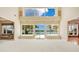 Bright living room featuring soaring ceilings, large windows with scenic waterfront views and neutral carpeting at 2504 Gatlin Ave, Orlando, FL 32806