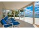 Covered patio with comfortable blue lounge chairs and a beautiful pool and lake view at 2504 Gatlin Ave, Orlando, FL 32806