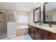 Well-lit bathroom featuring a soaking tub, glass enclosed shower and granite countertops at 2831 Orange Haven Way, Kissimmee, FL 34746