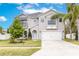 Charming two-story home featuring a well-manicured lawn, attached two car garage and mature trees at 2831 Orange Haven Way, Kissimmee, FL 34746