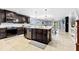 Spacious kitchen with a center island, dark cabinetry, and a view of the dining and living areas at 2831 Orange Haven Way, Kissimmee, FL 34746