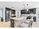 Well-appointed kitchen featuring a large island with granite countertops, dark cabinets, and stainless steel appliances at 2831 Orange Haven Way, Kissimmee, FL 34746