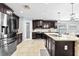 Open-concept kitchen featuring granite countertops, a large island with seating, and modern stainless steel appliances at 2831 Orange Haven Way, Kissimmee, FL 34746