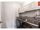 Convenient laundry room with modern washer and dryer set and upper cabinets at 2831 Orange Haven Way, Kissimmee, FL 34746