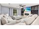 Inviting living room boasts a large sectional sofa, media center, and views of the screened pool at 2831 Orange Haven Way, Kissimmee, FL 34746