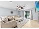 Comfortable living room featuring a large sectional sofa and a view of the screened pool area at 2831 Orange Haven Way, Kissimmee, FL 34746