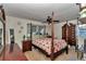 Spacious bedroom boasts a four-poster bed, ceiling fan, and ample natural light at 2833 Ne 18Th Ct, Ocala, FL 34470