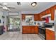 Open kitchen with tile flooring, stainless steel appliances, wooden cabinets and access to the lanai at 2833 Ne 18Th Ct, Ocala, FL 34470