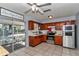 Bright kitchen with tile floors, wooden cabinets, stainless steel appliances, and a view of the lanai at 2833 Ne 18Th Ct, Ocala, FL 34470