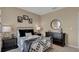 Stylish bedroom with a metal bed frame, patterned bedding, dark furniture, and tasteful wall art at 2972 Moulin Rd, Davenport, FL 33837