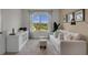 Bright living room with a white sofa, decorative stools, large window, and modern decor at 2972 Moulin Rd, Davenport, FL 33837